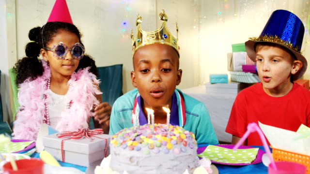Boy-blowing-candles-on-cake-during-birthday-4k