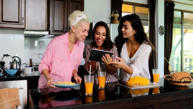 Mädchen-Gruppe-Einsatz-Tablet-Computer-sprechen-Clink-Saft-kochen-Frühstück-Frauen-modernes-Haus-innen-Küche-Studio