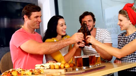 Group-of-friends-toasting-bottle-of-beer-4k