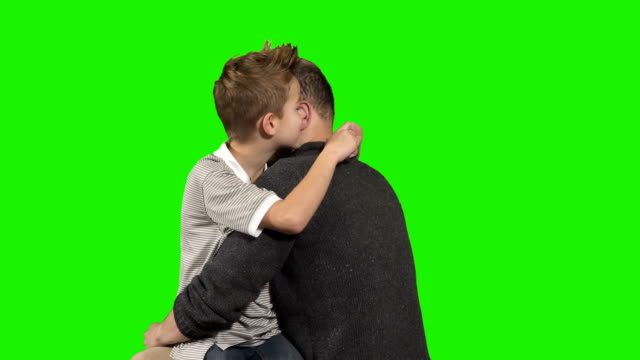 Kleiner-Junge-flüstert-Geheimnis-am-Ohr-seines-älteren-Bruders-auf-grünem-Hintergrund