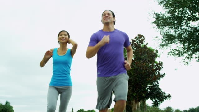 Young-Ethnic-male-female-keeping-fit-jogging-outdoors