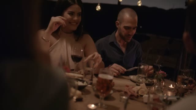 Young-couple-having-fun-at-elegant-rustic-dinner-party