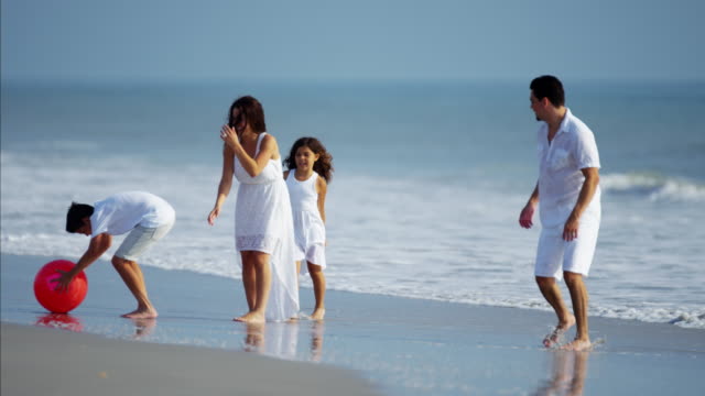 Latein-amerikanischen-Familie-spielen-zusammen-auf-Urlaub-am-Strand