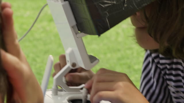 Junge-Mädchen,-die-eine-Drohne-spielen-im-Freien-im-Sommer-im-grünen-Rasen-Feld-remote-pilot-Zeitlupe-fliegen