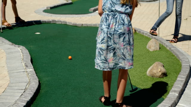 Niños-jugando-golf-en-miniatura-en-el-jardín-4k
