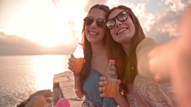 Hipster-Mädchen-im-Teenageralter-unter-Selfies-und-trinken-Limonade-am-Strand