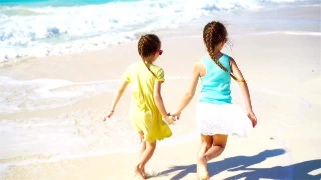 Adorable-little-girls-during-summer-vacation-having-fun-on-white-beach