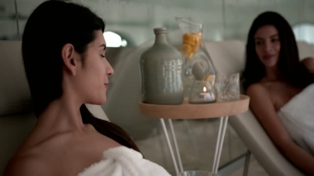 Mujeres-jóvenes-con-toallas-relajantes-en-el-spa-center