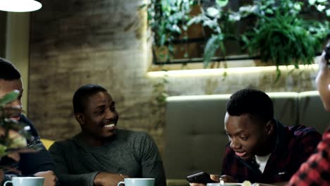 Negras-amigos-alegres-disfrutando-de-la-reunión-en-la-cafetería