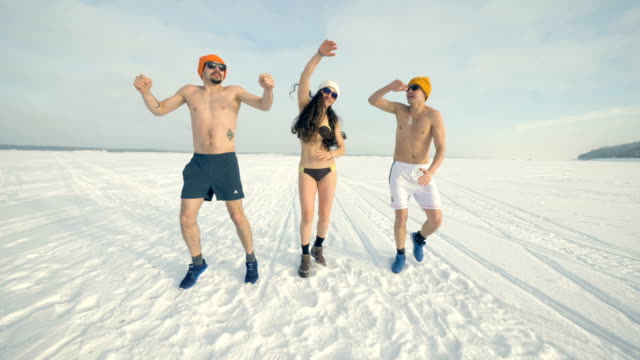 Three-friends-dance-and-jump-during-cold-training-while-wearing-swimsuits.-4K.