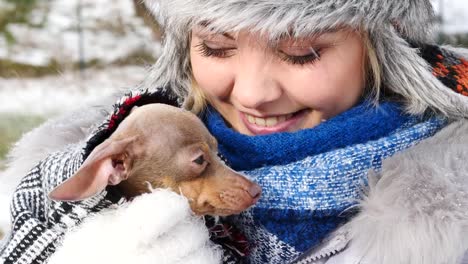 Woman-playing-with-her-little-dog-outside-winter