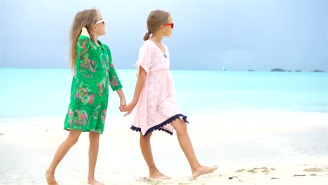 Entzückende-kleine-Mädchen,-eine-Menge-Spaß-am-tropischen-Strand-Hintergrund-blauem-Wasser-und-blauer-Himmel-zusammen-zu-spielen