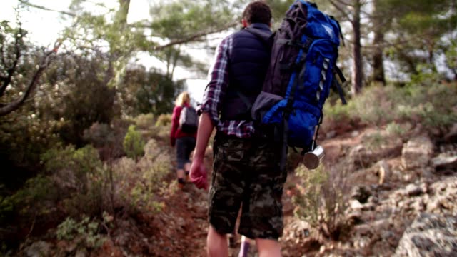 Group-of-hikers-with-backpacks-walking-up-a-mountain