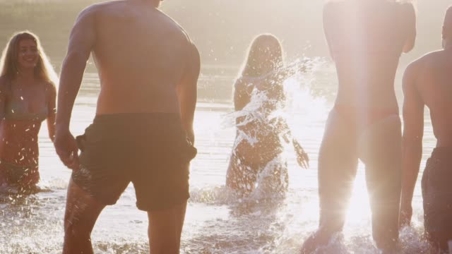 Jóvenes-amigos-adultos-de-vacaciones-que-se-divierten-chapoteando-en-el-lago