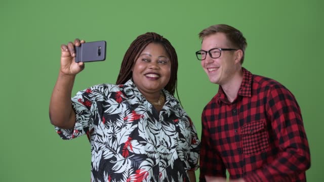 Overweight-African-woman-and-young-Scandinavian-man-together-against-green-background