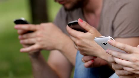 Nahaufnahme-der-Hände-SMS-auf-Smartphone-im-park