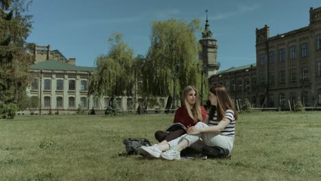 Entspannen-Sie-sich-auf-dem-Campus-Rasen-glücklich-Studentinnen