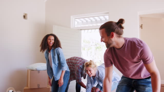 Slow-Motion-Shot-Of-Friends-Help-Couple-To-Carry-Boxes-Into-New-Home-On-Moving-Day