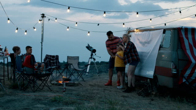 Personas-con-los-niños-jugando-charadas-en-camping