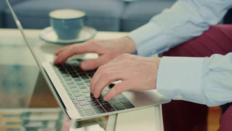 Hombre-de-negocios-utilizando-la-computadora-portátil-en-la-mesa-de-cristal-en-hogar-oficina-4K