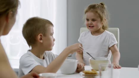 Cute-Girl-Chatting-with-Mother-and-Brother-at-Breakfast