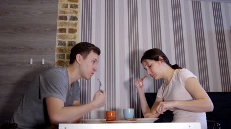 Hombre-joven-y-mujer-comiendo-en-mesa