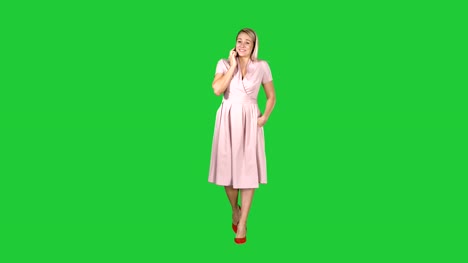 Portrait-of-walking-happy-young-woman-talking-on-mobile-phone-and-smiling-on-a-Green-Screen,-Chroma-Key