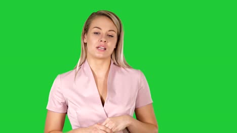 Pretty-beautiful-woman-with-blonde-hair-dressed-in-pink-walking-and-talking-on-a-Green-Screen,-Chroma-Key