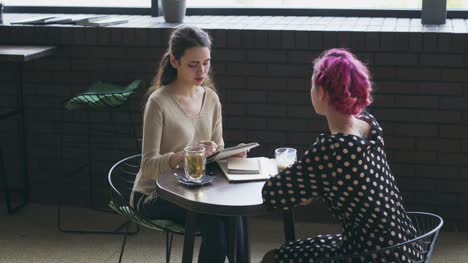 Frau,-Skizze-und-im-Gespräch-mit-Freund-im-café