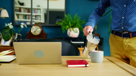 Geschäftsmann-gießt-die-Tasse-Kaffee-in-seinem-Heim-Büro