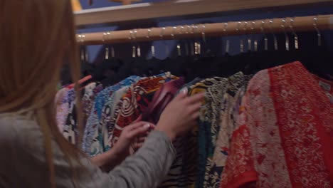 Two-friends-looking-at-shirts-with-bright-patterns-in-a-store