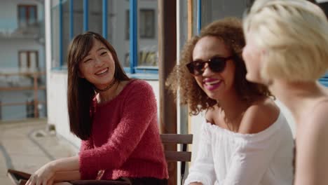 Three-women-friends-meeting-at-outdoor-cafe
