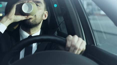 Hombre-de-negocios-conduciendo-un-coche-por-la-mañana,-tomando-café.