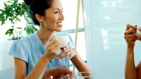 Smiling-executive-interacting-while-having-a-cup-of-coffee