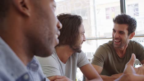 Three-Male-Friends-Meeting-In-Coffee-Shop-Shot-In-Slow-Motion