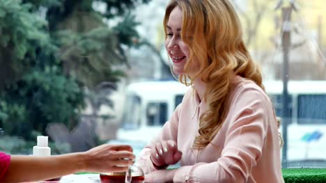Blonde-genießen-heißen-Tee-und-Gespräche-mit-Freund-im-café