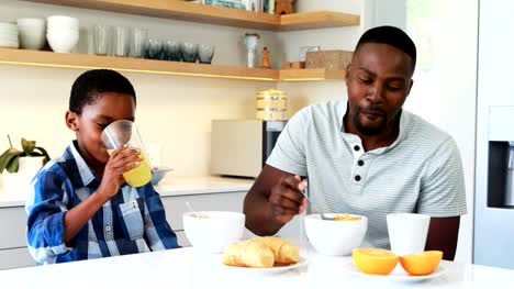 Father-and-son-having-breakfast-in-kitchen