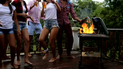 Young-People-Dancing-While-Cooking-Barbecue-Frineds-Group-Gathering-On-Summer-Terrace-Having-Party-Legs-Closeup-View