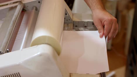 White-male-working-with-roll-laminator