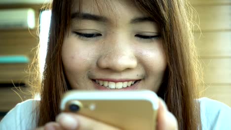 Frau-mit-app-auf-dem-Smartphone-im-Café-trinken-Kaffee-lächelnd-und-SMS-auf-dem-Handy.-Schöne-multikulturelle-lässig-weibliche-Berufseinsteiger-auf-Handy.-Gemischte-Rassen-asiatischen-kaukasischen-Modell.