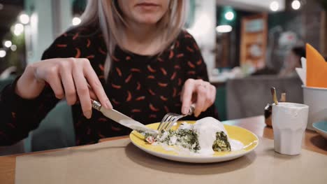 Irreconocible-chica-comer-strudel-de-postre-en-el-restaurante-con-tenedor-y-cuchillo