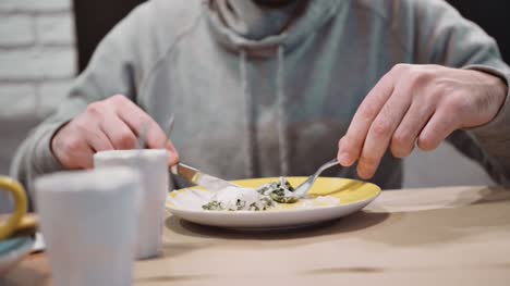 Unrecognizable-man-eating-dessert-strudel-at-the-restaurant-using-fork-and-knife