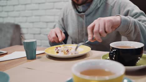 Unrecognizable-girl-eating-dessert-strudel-at-the-restaurant-using-fork-and-knife