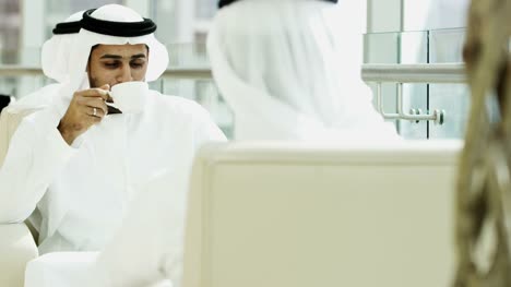 Male-female-Emirati-travellers-drinking-coffee-hotel-lobby