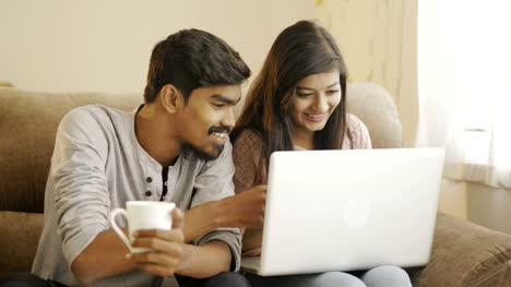Happy-young-friends-using-laptop