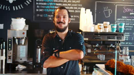 Porträt-von-männlichen-Barista-hinter-Theke-In-Coffee-Shop