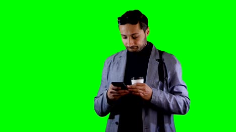 Man-in-suit-a-use-mobile-and-hold-coffee-cup.-Green-screen,-footage.