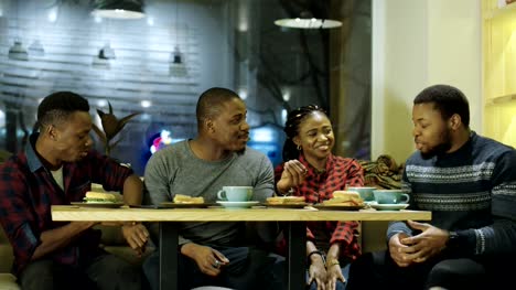 Schwarzen-fröhlichen-Freunden-treffen-im-Café-genießen