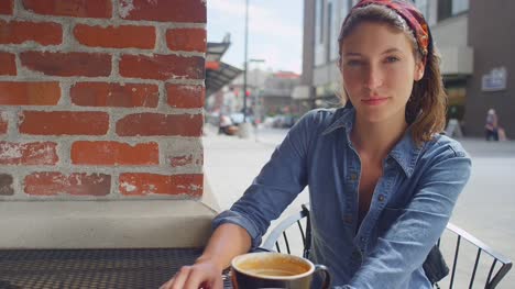 Mujer-joven-inconformista-sentado-afuera-de-una-tienda-de-café,-retrato