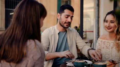 Young-couple-having-fun-with-friends-at-traditional-coffee-shop